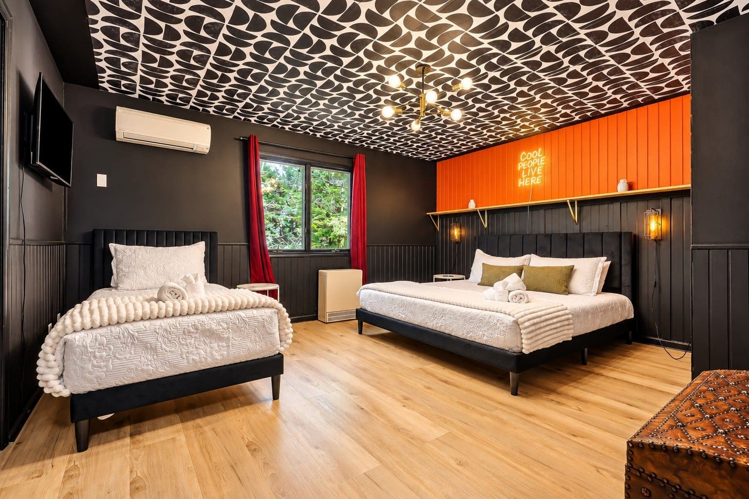 Bedroom with two beds and an orange accent wall