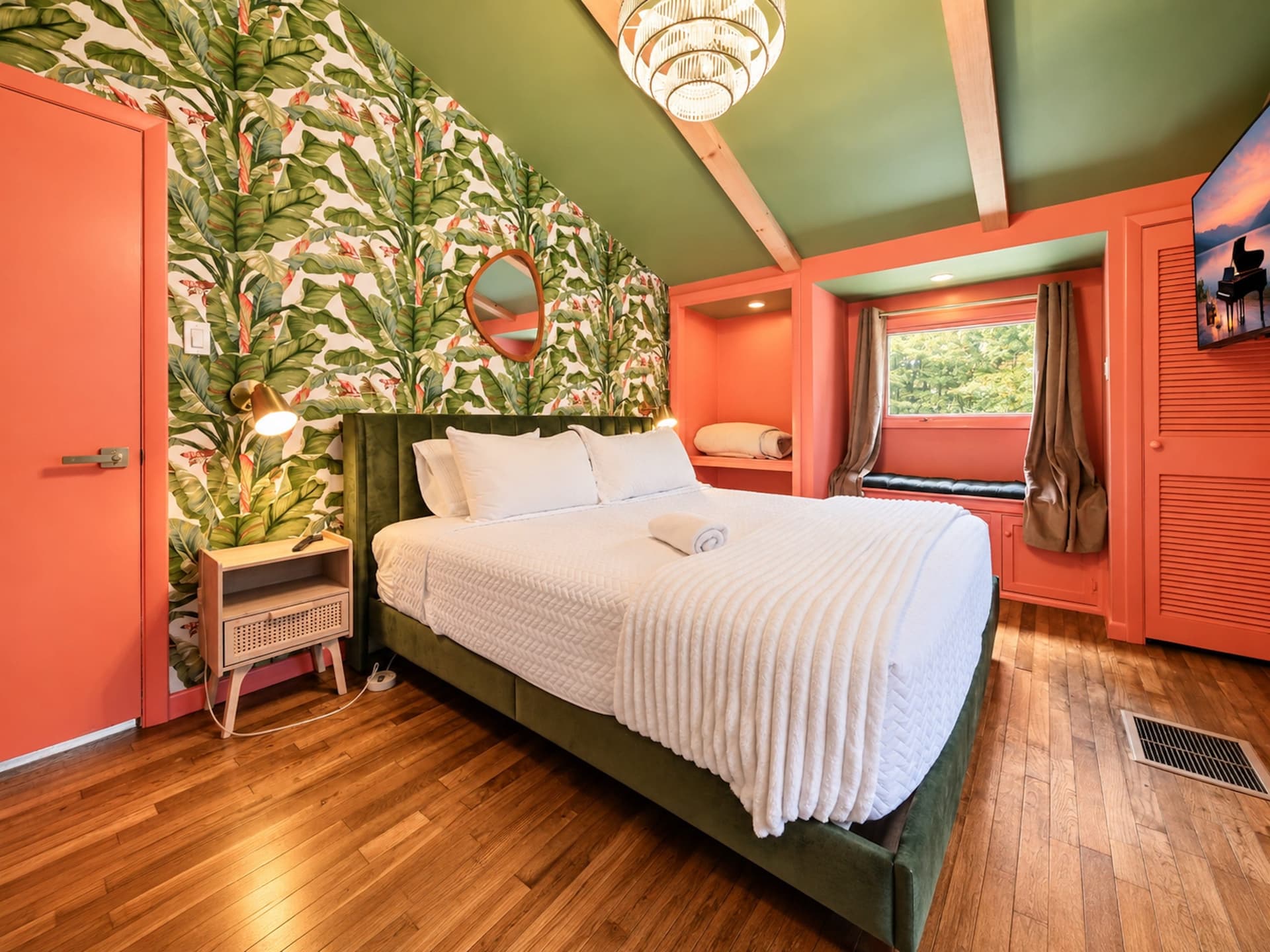 Bedroom with tropical wallpaper and a velvet bed